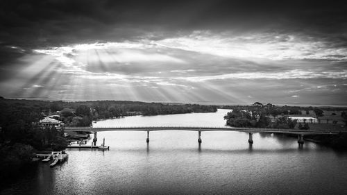 Bridge over river against sky in city