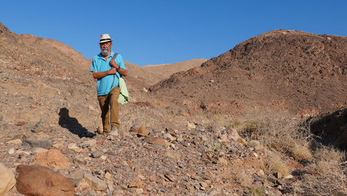 Senior man walking on mountain in the desert 