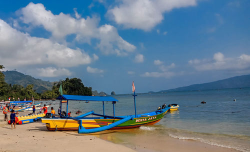 Boats moored on beach against sky