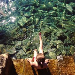 Rear view of woman swimming in water