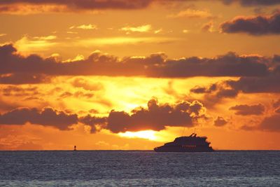 Scenic view of sea against dramatic sky during sunset