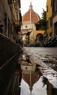 Duomo santa maria del fiore reflecting in puddle on street