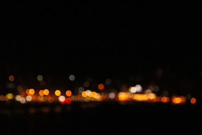 Defocused lights against sky at night