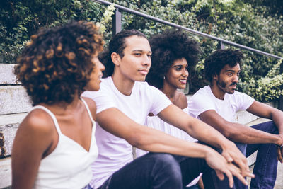 Friends looking at man sitting in park