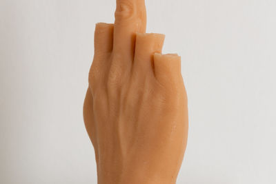 Close-up of person holding hands against white background