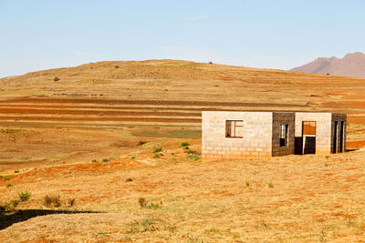 Built structure on field against sky