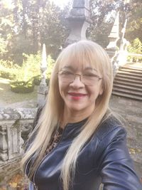 Portrait of smiling young woman against trees