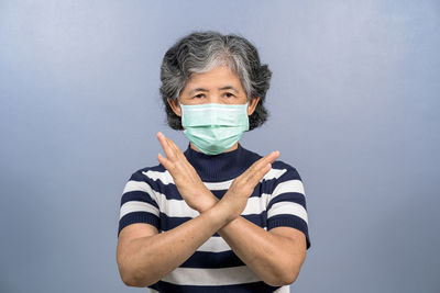 Portrait of mature man standing against blue background