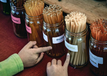 High angle view of hand holding jar on table