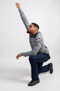 Young man looking away against white background