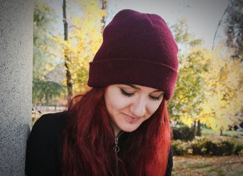 Close-up of beautiful young woman wearing knit hat at park