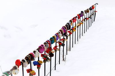 Low angle view of padlocks hanging on railing against sky