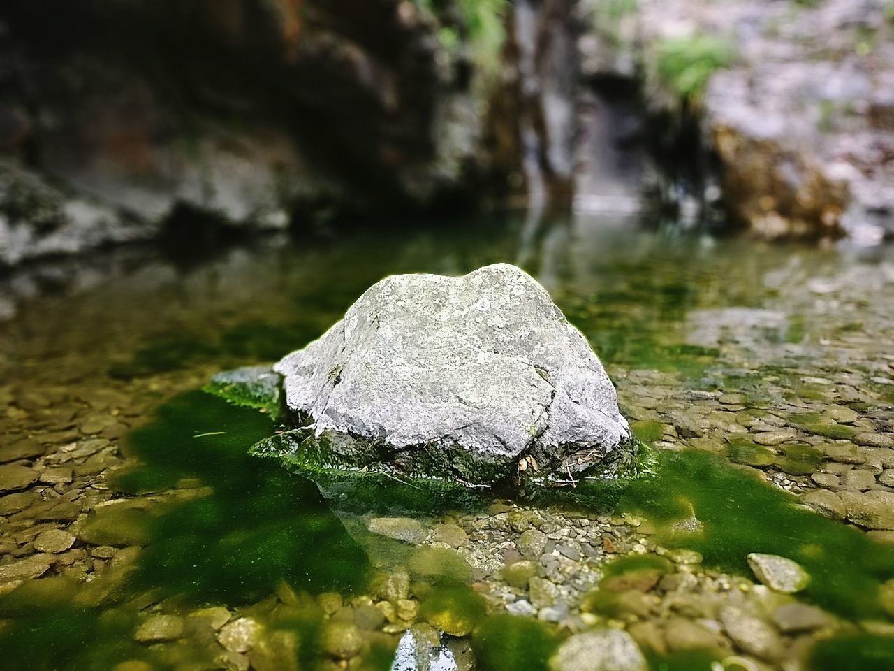 CLOSE-UP OF ROCK ON RIVER
