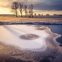 A beautiful frozen pond in the rural scene during the morning golden hour. 