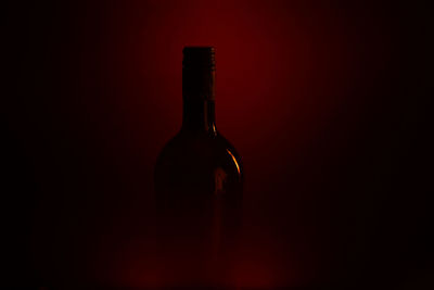 Red wine bottle against black background