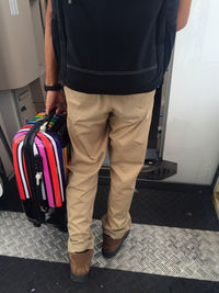 Low section of man carrying luggage in airplane