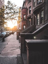 Street amidst buildings in city during sunset