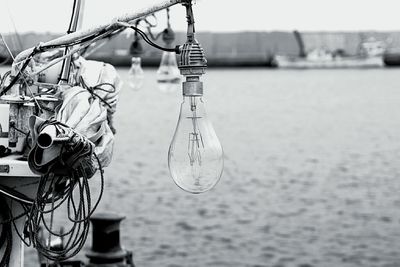 Close-up of bicycle hanging on boat in sea against sky