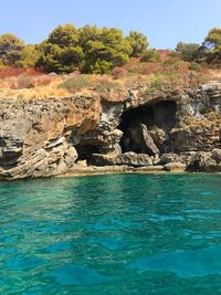 Scenic view of rocks in sea against sky