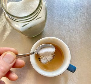 Hand holding coffee cup on table