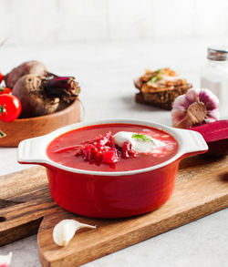 Delicious fresh red borscht, garlic, tomatoes and beets on the kitchen table.