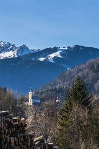 Coccau church and lussari ski slopes in the background. tarvisio in winter to be discovered. italy