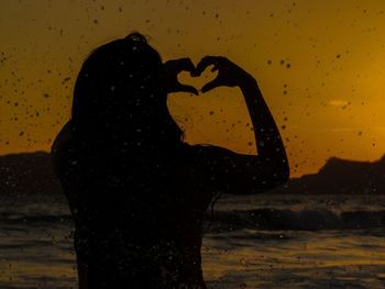 Close-up of wet heart shape against sky during sunset