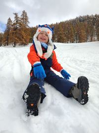 Portrait of cute girl skiing on snow covered field