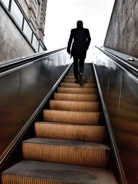Rear view of man walking on stairs