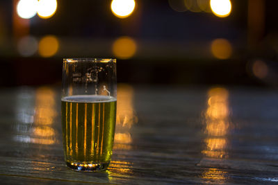 Glass of beer with blurred lights on background