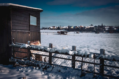 Scenic view of river by buildings against sky during winter