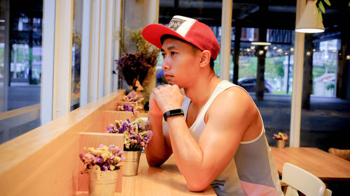 Side view of man looking away while sitting in restaurant