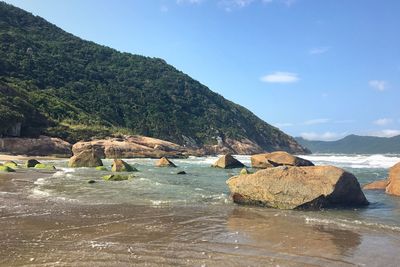 Scenic view of sea and mountains against sky