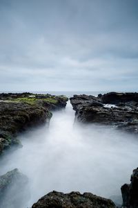 Scenic view of waterfall against sky