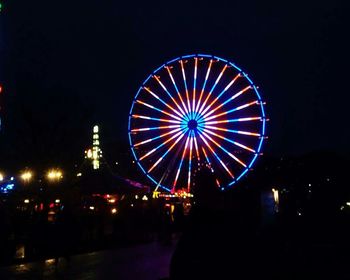 Illuminated ferris wheel at night