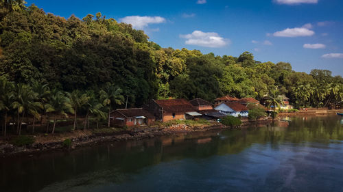 Scenic view of lake by trees and buildings against sky