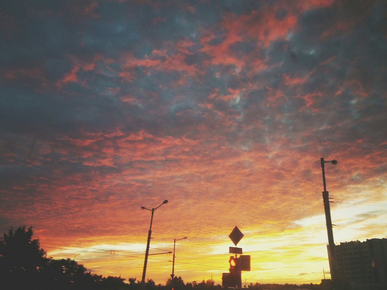 sunset, silhouette, sky, low angle view, cloud - sky, orange color, beauty in nature, street light, scenics, cloudy, tranquility, nature, cloud, dramatic sky, tranquil scene, tree, power line, idyllic, outdoors, dusk