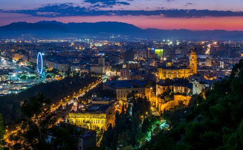 High angle view of illuminated city against sky at dusk