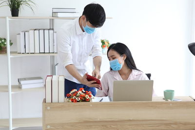 Businessperson wearing mask looking at digital tablet