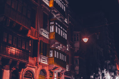 Low angle view of illuminated buildings in city at night