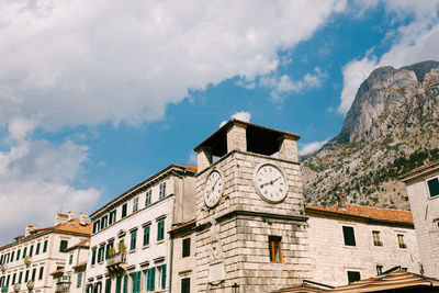 Low angle view of buildings against cloudy sky