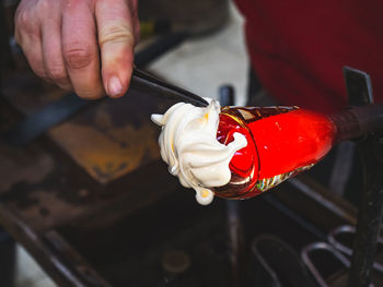 Glass-blower artist create white layer. man working with hot glass to make a blown glass art piece