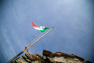 Low angle view of flag against blue sky