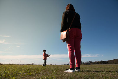 Mother and son on land against sky