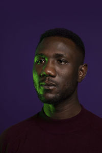 Close-up portrait of young man against blue background