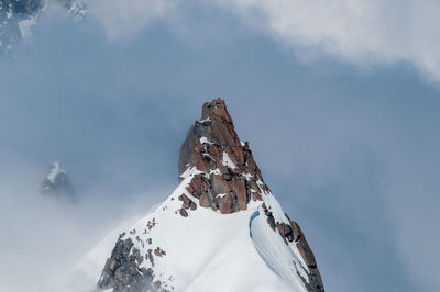 Low angle view of snowcapped mountain against sky