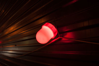 Illuminated red lighting equipment on corrugated iron