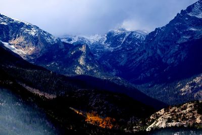 Scenic view of snowcapped mountains against blue sky