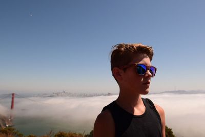 Boy wearing sunglasses against clear sky