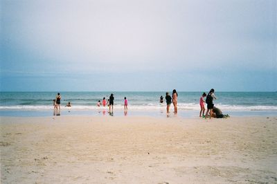 People on beach against sky